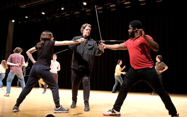 Students and teacher sword fighting on stage in weston in stage movement class