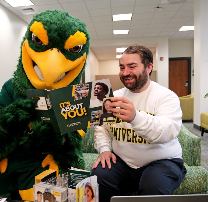 Freddy and Tyler looking at viewbook in welcome center/admissions