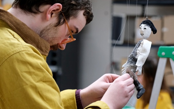 Student working on a puppet in class