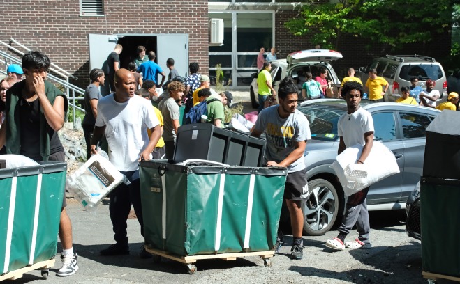 Families with bins at move in outside dorm