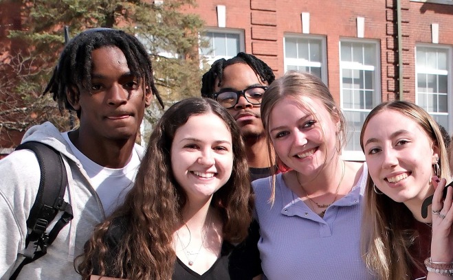 Male and female smiling students on quad