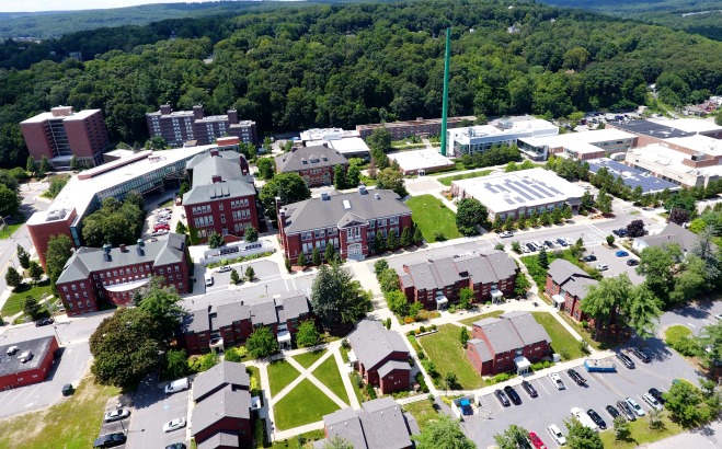Aerial drone shot of campus buildings from Cedar St facing smokestack