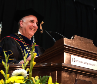 President Lapidus smiles at podium at Grad Commencement Spring 2024