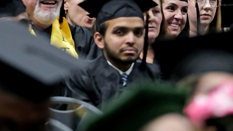 Male and female graduates smiling and celebrating at winter commencement 23