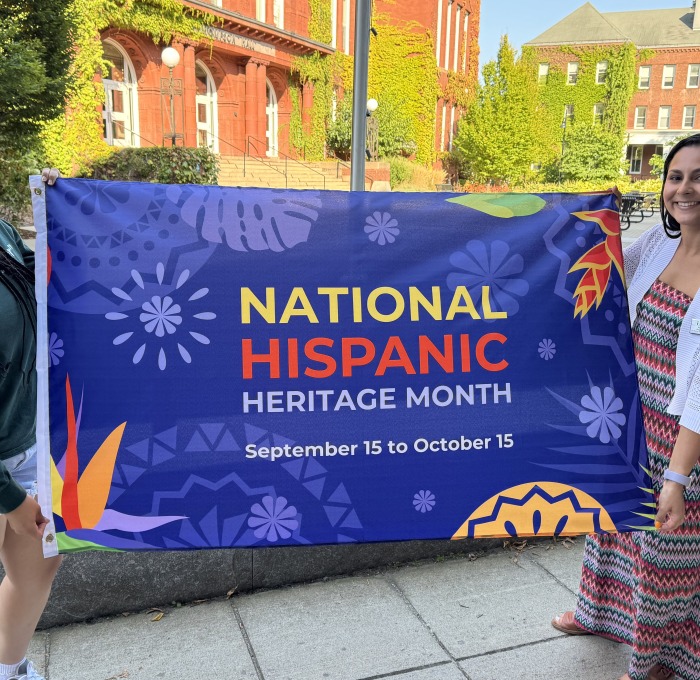 Krysta and student holding National Hispanic Heritage Month flag on alumni quad before flag raising