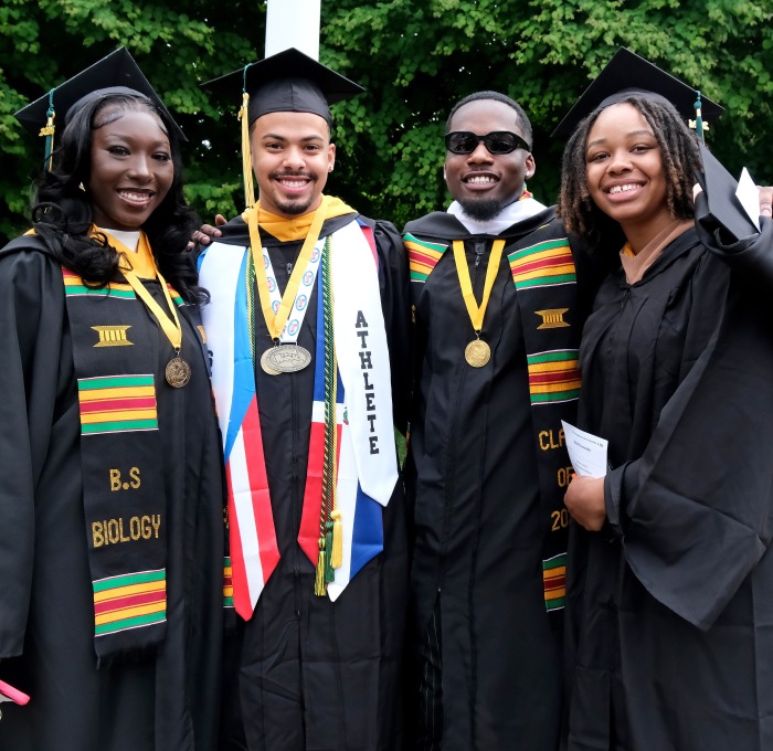 Group of smiling grads outside at undergrad commencement