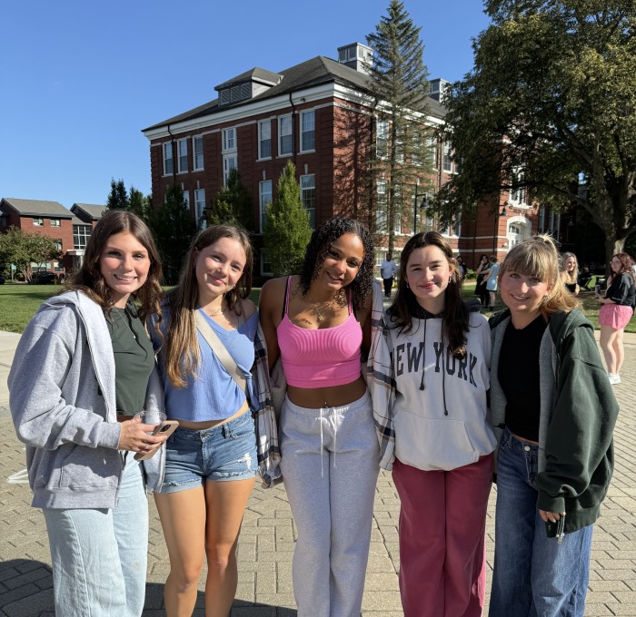 Group of female first year students smiling on the quad