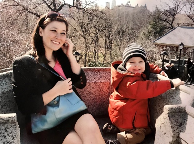 Elise Takehana, Ph.D., sitting on a stone bench with a child