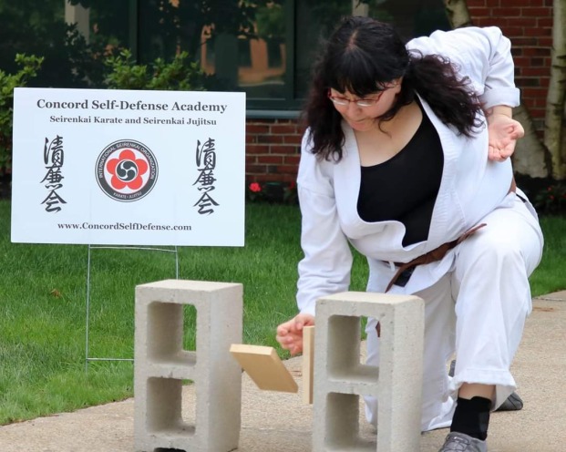 Kisha Tracy, Ph.D. breaking a block of wood while practicing Karate