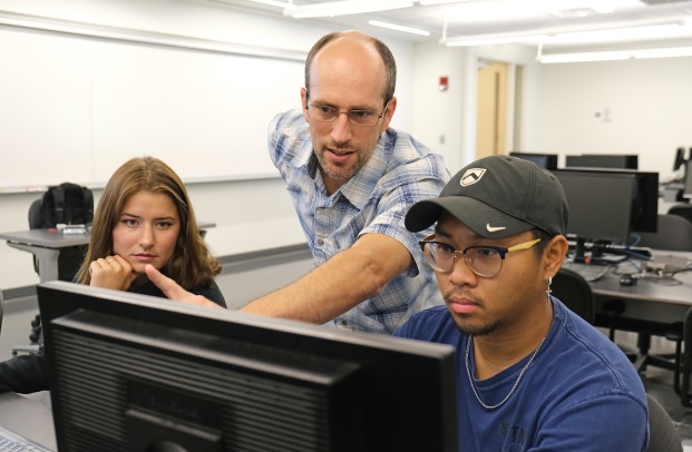 Dr. Reid Parsons helping students on a computer