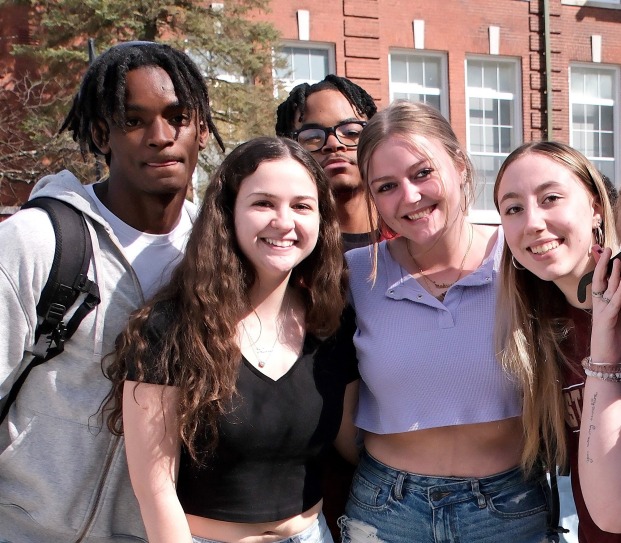 Male and female smiling students on quad