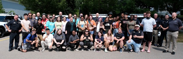 RA training group with University Police at police headquarters with cars in background