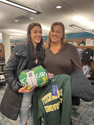 Mom and daughter in bookstore with swag sweatshirt and blanket